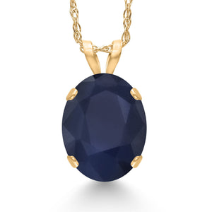 Oval dark blue gemstone solitaire pendant set in a four-prong 14K yellow gold setting on a matching gold chain